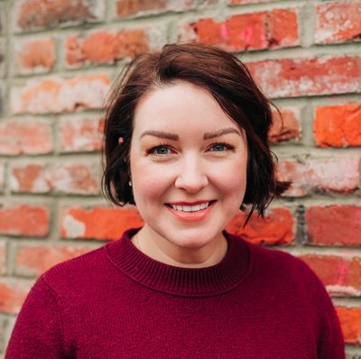 Elsie Raymond wearing a red sweater and smiling